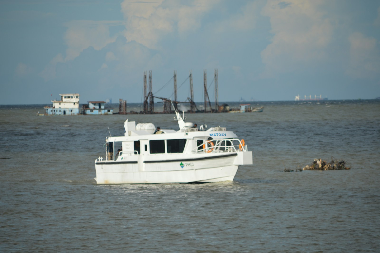 White boat sailing on a calm blue sea.